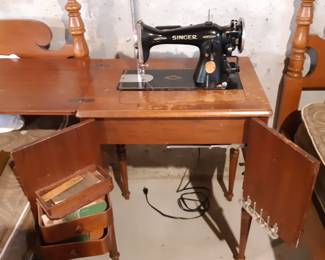 Vintage Singer sewing machine with cabinet and stool.