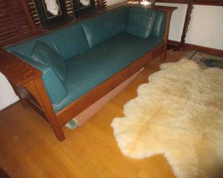 Huge sheepskin rug, arts/crafts era oak sofa with leather....gorgeous.