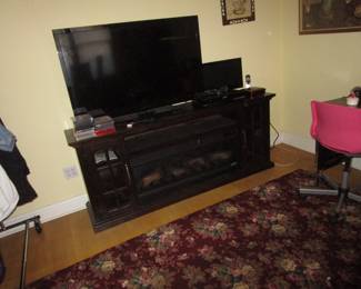 Several flat screen TV's this one on a plug in fireplace, perfect for fall and winter