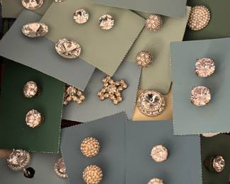 Hundreds of pairs of earrings in multiple containers 