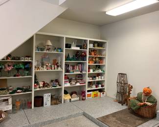 In the garage there is a wall filled with holiday decor, mugs, and outdoor items. 