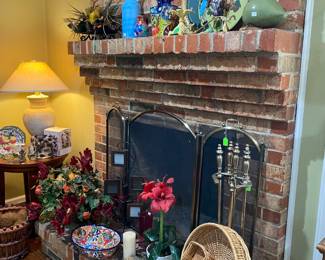 Mantel full of collectibles including Talavera jug and bowl, fireplace screen and tools