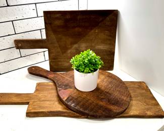 All SOLD $30; square, rough-hewn charcuterie board.     $30; round, rough-hewn charcuterie board.         $28; rectangular, rough-hewn charcuterie board.    $4; faux green plant