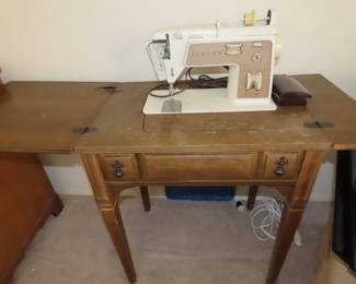 Singer sewing machine in cabinet.