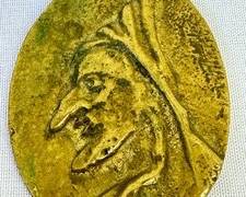 Vintage Brass Pendant with what appears to be an embossed image of a fairy tale character. 

Item in good condition with some light wear. Measures about two inches. 