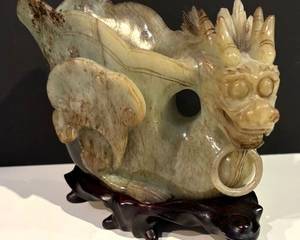 Vintage Carved Hard Stone Dragon Sculpture

Semi-transparent with russet inclusions; dragon head with ring neck and vessel body; internal cracks and brown stained highlights

Measures 5 ½ inches high including affixed wood stand.