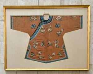 Framed Antique Chinese Embroidered Tunic or Jacket 

Tunic or jacket, silk and metal thread, framed and matted with gold fillet, Chinese, probably late Qing dynasty; Manchu style (qizhuang)

Features proper left over right fold, embroidered flora on fiber-patterned orange silk, solid sky-blue trim

Item has some wear including; slightly uneven color fade, several spots of deteriorated applied threads

Textile (sight): 26 ½ inches high by 40 inches wide; Frame: 35 inches high by 47 ¾ inches wide.
