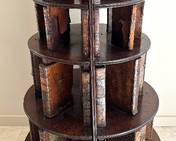 Antique Mahogany and Leather George III Design Round Bookshelf
Bookcase, mahogany and leather, George III design. Probably English and 19th century
Features five graduated circular tiers on raised base, each shelf with leather-bound- book dividers
Item in vintage condition, normal condition of age. Shows nicks and indentations to mahogany and dry, distressed and flaking leather
Measures; 39 ¾ inches high by 22 ½ inches 
