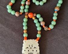 Vintage Jade and Coral Beaded Necklace accented with a lovely carved pendant

Measures about 28 inches long. 