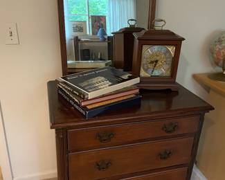 Four-drawer chest of drawers, mirror, Mantle clock, and coffee table books
