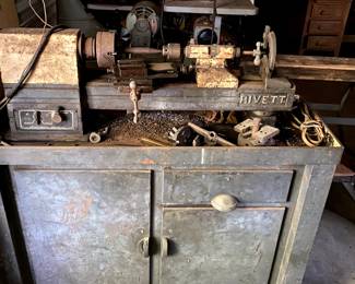 Metal lathe on a heavy steel cabinet.