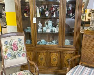 Beautiful needlepoint rocker, shown with dining chair and china cabinet filled with Bryers carolers and china.
