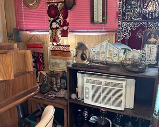 There is a wall A/C unit on the shelf, as well as the various other decorative items.