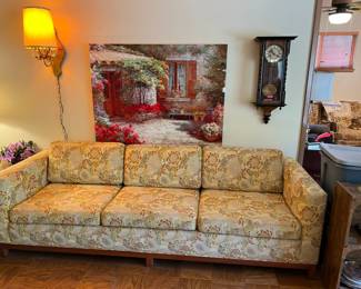 This is the matching sofa to the loveseat. Notice also the small pendulum clock on the wall, and the quaint courtyard picture on the wall.