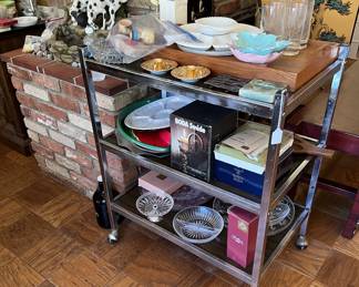 Multiple kitchen and serving dishes are hiding out on this rolling serving cart.