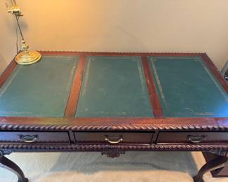 Inset leather top carved mahogany desk