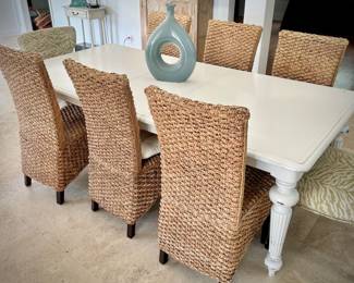 White painted dining table with - can sit 8-10 people with leaf in it. Six sisal/rattan chairs and two upholstered green chairs.