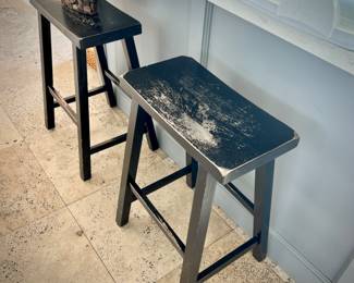 Two black distressed counter top stools
