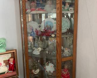 Glass fronted curio cabinet with dolls and figurines