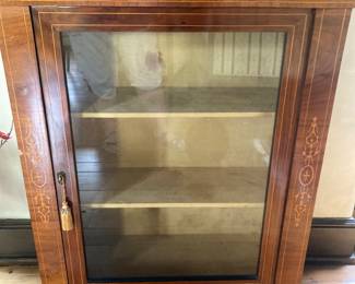 $225; Small curio cabinet with inlay: 29.5” wide; 11.5” deep; 40.5” tall. 3 shelves, 2 adjustable. Small chip in the veneer on the left side. Has keys. 