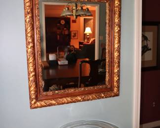 An old decorative mirror that has had the gold repaired, in the kitchen