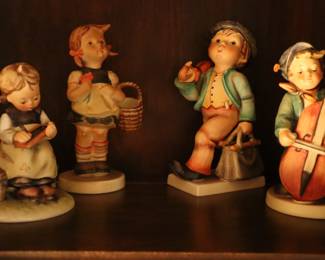 Early Hummel figurines inside of secretary