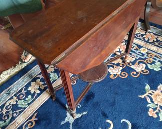 Drop leaf mahogany occasional table with stretcher and circular platform, circa 1920, likely English.