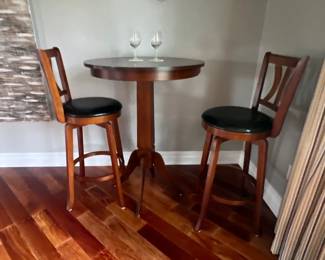 pub table, brown and black pleather seats, high top round table and chairs