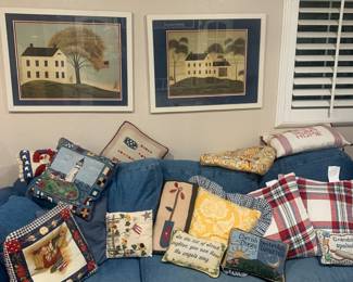 Lots of decorative pillows, denim couch, pictures