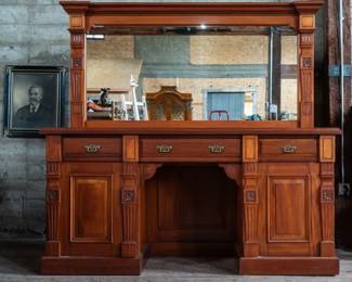 A beautifully restored bar back made by Audas & Leggott Cabinetmakers of England, circa 1877-1886 with three top drawers, and two large cabinets, the one on the right containing an antique cellarette. Bottom cabinets feature locking mechanisms, unlocked with no keys included.