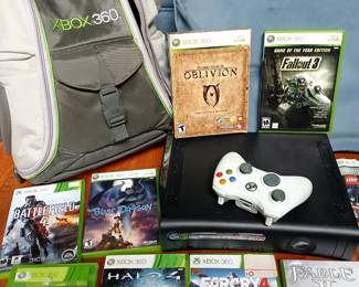Xbox 360 with an assortment of games including fallout , farcry , and Halo