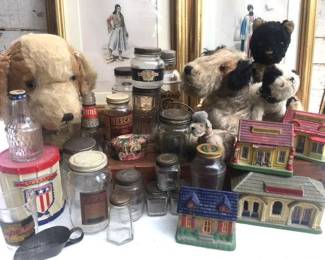 Puppy dogs watching over a sampling if old advertising jars and tins