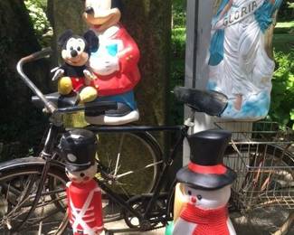 Several vintage Schwinn bicycles and lots of outdoor Christmas blow mold decorations...even mickey mouse.