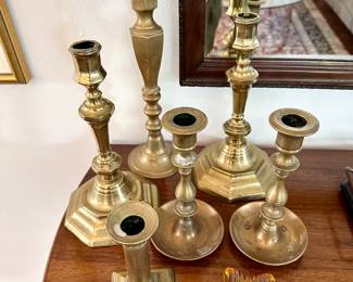 A nice collection of brass candlesticks and star paperweight.