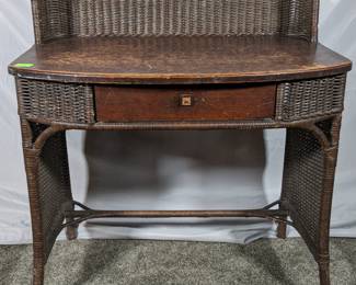Lot 104: Heyward Wakefield woven table with wooden top and single drawer, measures 36 " high to top of back gallery x 32 " wide x 20.5 " deep