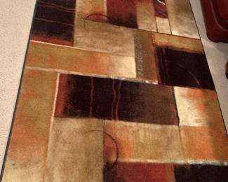 Area rug. 60 x 95. Located in the basement. The white and black half circles are part of carpet pattern not stain