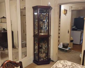 Curio cabinet full of silverplate serving pieces