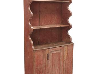 23
An American Pine Step-Back Cupboard
Mid-18th century; Hudson Valley, NY
The red painted cupboard with carved wavy side panels and two shelves above a single cabinet door with iron hinges revealing a single inner shelf
72.75" H x 34.75" W x 15" D
Estimate: $1,500 - $2,500