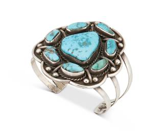 254
A Southwest Silver And Set Turquoise Cuff Bracelet
Early/mid-20th century
Appears unmarked
A three-wire cuff with chunky cluster set turquoise on a scalloped plaque with silver ball accents
6.25" total inner C x 2.5" H, with a 1.125" gap
59.9 grams gross
Estimate: $400 - $600