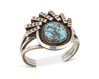 257
A Southwest Silver And Turquoise Cuff Bracelet
Early/mid-20th century
Appears unmarked
A small three-wire cuff with a shadowbox set turquoise stone flanked by stamped silver bar accents
6.25" total inner C x 2" H, with a 1.125" gap
89.7 grams gross
Estimate: $400 - $600