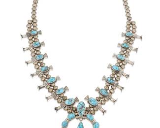 228
A Navajo Silver And Turquoise Squash Blossom Necklace
Mid/late 20th century, Diné
Appears unmarked
A sterling silver and set turquoise necklace with fourteen stamped butterfly "blossoms" and a central naja with teardrop dangle
26.25" L x 2.75" H
135.1 grams gross
Estimate: $700 - $900