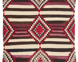 77
A Navajo Third Phase Chief's Blanket
Late 19th century, Diné
A banded blanket woven in cream, light and dark brown, red, dark blue, turquoise, and purple wool, with columns of checkered diamonds
58" H x 63.5" W
Estimate: $2,000 - $3,000