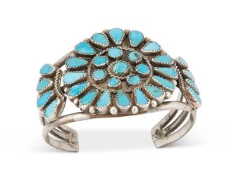 259
A Southwest Silver And Turquoise Cuff Bracelet
Early/mid-20th century
Appears unmarked
A three-wire cuff with a cluster set turquoise central round plaque and shoulders
6.375" total inner C x 1.875" H, with a 1.25" gap
60.2 grams gross
Estimate: $400 - $600