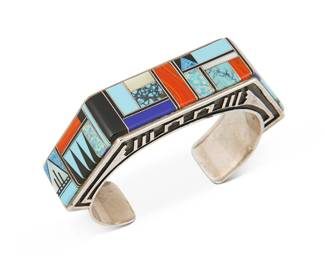 253
A Southwest-Style Sterling Silver And Stone Inlay Cuff Bracelet
Late 20th/21st century
Stamped: JM / Sterling [within a decorative stamped cartouche]
Comprising a cuff with overlay side panels supporting a raised multistone mosaic channel inlay table and sides, including turquoise, lapis lazuli and opal
6.5" inner C x 0.75" H, with a 1.125" gap
70.8 grams gross
Estimate: $600 - $800