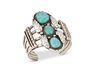 255
A Southwest Silver And Turquoise Cuff Bracelet
Early/mid-20th century
Appears unmarked
A four-wire cuff with oblong central plaque with three set turquoise stones and silver overlay motifs
6.25" total inner C x 2.75" H, with a 1" gap
83.4 grams gross
Estimate: $400 - $600