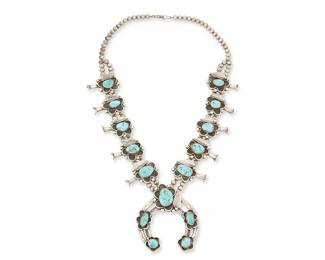 226
A Southwest Silver And Turquoise Squash Blossom Necklace
Early/mid-20th century
Appears unmarked
A double strand sterling silver necklace with ten set turquoise shadowbox style blossoms and a central naja with multiple set turquoise floral motif plaques
27.5" L x 3.5" H
246.0 grams gross
Estimate: $700 - $900