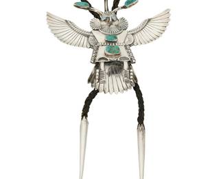 246
A Navajo Sterling Silver Katsina Bolo
Attributed to Helen Long (b. 20th century, Diné)
Appears unmarked
A winged silver katsina figure bolo with set turquoise, mounted to a braided leather cord and finished with silver cone and ball tips
Bolo: 4.5" H x 4.75" W; Cord with tips: 40" L
94.2 grams gross
Estimate: $600 - $800