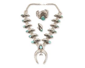 225
A Set Of Roy Vandever Navajo Silver And Turquoise Jewelry
Roy Vandever (1936-2009, Diné)
Mid/late 20th century
Naja signed in etched script: By Roy Vandever
Three works comprising an elaborate double-strand squash blossom necklace with turquoise and silver overlay "blossoms" with a central two-wire naja (25.25" L x 3.5" H), together with a matching four-wire cuff bracelet with set turquoise and incised silver and silver wire overlay (6.25" total inner C x 2" H, with a 1.125" gap) and a matching ring (ring size: 8; 1.75" H), 3 pieces
279.7 grams gross
Estimate: $800 - $1,200