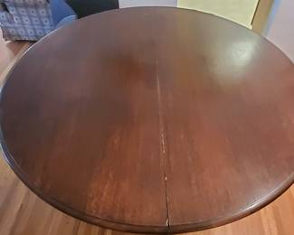 Vintage round walnut color table has (4) 12" leaves