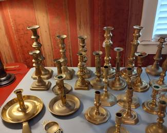 A huge collection of cast brass candlesticks dating from the early 18th century to the very early 20th century
